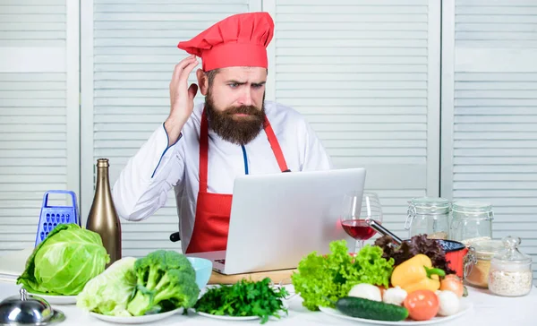 Kulinarische Bildung online. Elearning Konzept. Man Koch auf der Suche nach Internet-Rezept Kochen Essen. Chef-Laptop liest kulinarische Rezepte. Kochschule. Hipster mit Hut und Schürze lernen, wie man online kocht — Stockfoto