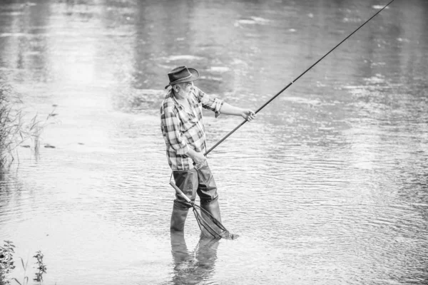 Homem sênior pegando peixe. Homem maduro pescando. Lazer masculino. Pescador com cana de pesca. Atividade e hobby. Pesca lago de água doce lagoa rio. Felicidade é vara em sua mão. Pescador aposentado — Fotografia de Stock