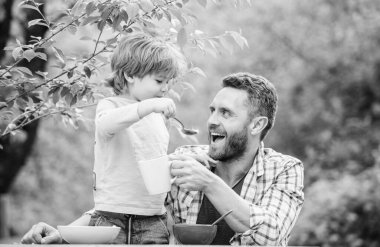 Bebeği besliyor. Çocuklar için menü. Aile ev yapımı yemeklerin tadını çıkarır. Baba oğul yemek yer ve eğlenir. Yemek alışkanlıkları. Babası yla birlikte yiyecek doğa geçmişi yiyen küçük bir çocuk. Yaz kahvaltısı. Sağlıklı gıda kavramı