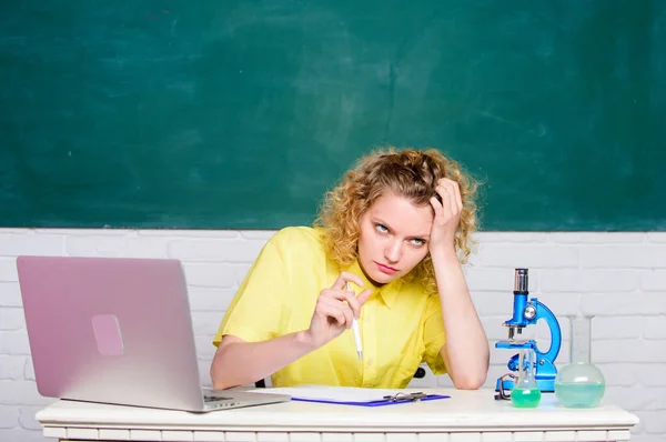 Make notes about chemistry research results. girl in classroom laboratory with computer. upset student with microscope beaker. biology experiment. scientist teacher at school lab. hard working day — Stock Photo, Image