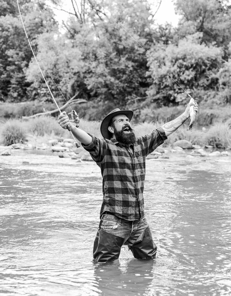 Hobby masculino. pasatiempo y actividad deportiva. pescador mostrar técnica de pesca uso de la caña. fin de semana de verano. Feliz pesca con mosca. Pescador barbudo en el agua. hombre maduro pesca con mosca. hombre captura de peces — Foto de Stock