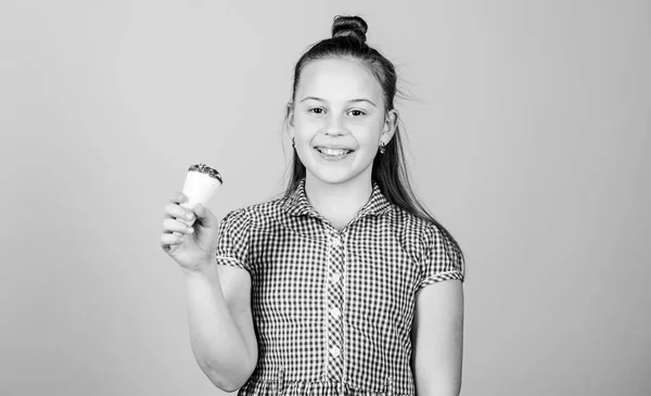 Conceito dos dentes doces. Menina pequena criança comer sorvete cone bege fundo. O verão chegou. Gelado delicioso. Feliz infância. Miúdo despreocupado desfrutar de sorvete doce. Dia internacional das crianças — Fotografia de Stock