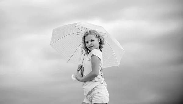 Glücklicher Kindertag. Genießen Sie Leichtigkeit. Sorgenfreies Kind im Freien. Mädchen mit Regenschirm bewölkten Himmel Hintergrund. Freiheit und Frische. Wettervorhersage. Bereit für jedes Wetter. Wetterumschwung. Frische Luft — Stockfoto