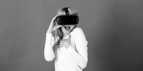 Porträt einer jungen Frau mit VR-Brille, die mit einem 3D-Headset virtuelle Realität erlebt. Erstaunte junge Frau, die während des VR-Erlebnisses die Luft berührt. Virtuelles 3D. — Stockfoto