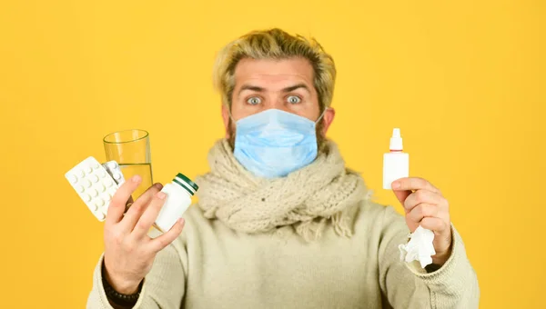 Farmaceutisch concept. Veel medicijnen. Preventie concept. Man ziek verlof thuis. Baard man rommelig haar dragen masker houden pillen vitaminen medicijnen in handen. Effectieve behandeling van geneesmiddelen — Stockfoto