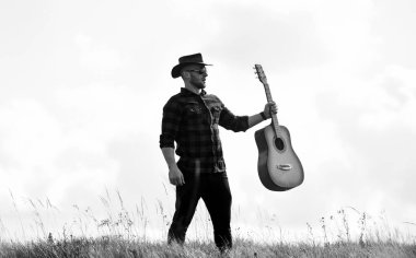 Country müzik konsepti. Gitarist country şarkıcısı arka planda duruyor. Köy tarzı. Yaz tatili. Yürüyüş şarkısı. Country müzisyeninden esinlendim. Doğayla bütünleşti. Gitarlı yakışıklı adam.