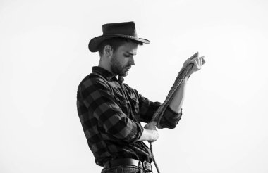 Çiftlik işçisi. Eko çiftliği. Çiftçilik kavramı. Şapkalı ve köylü tarzı kıyafetli yakışıklı bir adam. Çiftlik kalsın. İşi düşünen düşünceli bir çiftçi. Çiftlikte hayat. Kement ipiyle gökyüzü arka planına sahip kovboy.