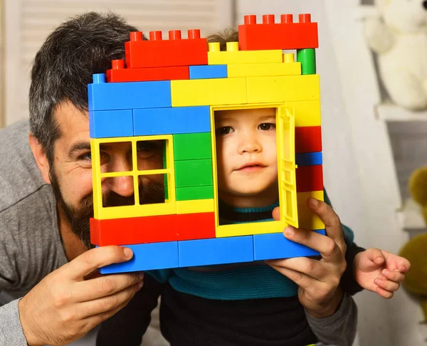 Papá y el niño se esconden detrás de una pared hecha de bloques — Foto de Stock