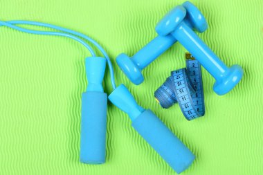 Dambıllar ve atlama halatı yeşil arka planda cyan renginde