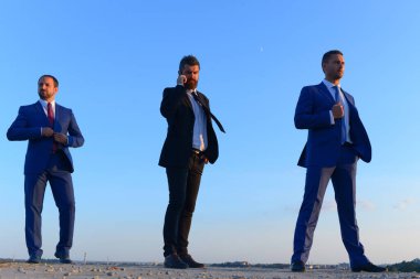 Takım elbiseli, kendine güvenen iş adamları.