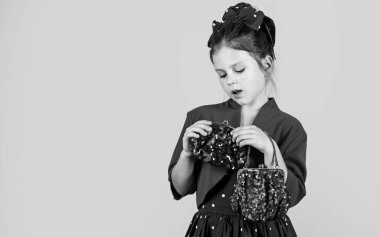 Zarif görgü kuralları konsepti. Klasik trend. Zarif retro çocuk. Küçük kız modası kıyafetleri. Göz alıcı bir aksesuar. Çanta çantası ve çanta aksesuarı. Eski model model. Sevimli küçük bayan