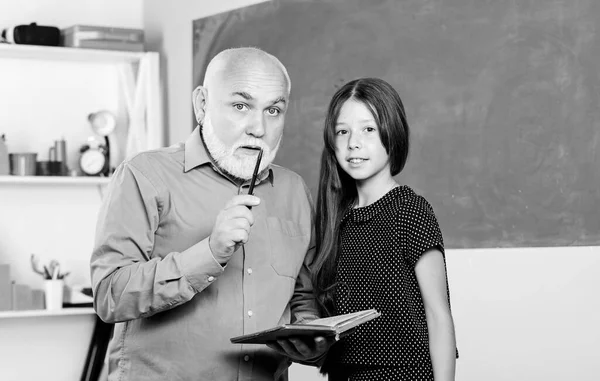 Questo è il mio libro. Torniamo a scuola. Leggi e scrivi. piccola ragazza con libro di studio tutor uomo. informazioni. Concetto di libreria. lezione di lettura scolastica. insegnante maturo aiuto allievo con la letteratura — Foto Stock