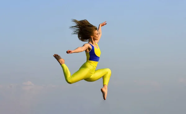 Menina pulando alto. desporto em movimento. cheia de energia. Mulher esportiva jovem atraente está trabalhando no ginásio ao ar livre. exercício matinal. Ginasta nacional ucraniana. Acrobática e ginástica — Fotografia de Stock