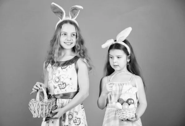 Какой-то кролик любит тебя. Маленькие девочки в повязке на Пасху. Девочки с пасхальными кроличьими ушами. Милые пасхальные кролики приносят яйца. Пасхальное яйцо - символ новой жизни — стоковое фото