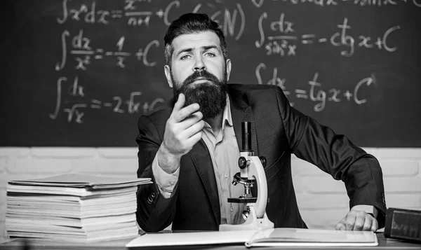 Educational conversation. Talking to students or pupils. School teacher concept. Teacher bearded man tell interesting story. Teacher charismatic hipster sit at table classroom chalkboard background