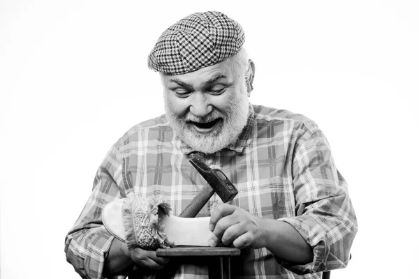 Loja de reparação de sapatos. Mestre sênior com martelo de reparação sapato. Sapatos feitos à medida. Conceito feito à mão. A desenhar sapato. Trabalhador trabalhador artesanal. Homem barbudo faz-tudo trabalhando com ferramentas fundo branco — Fotografia de Stock