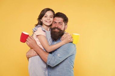 Susuz kalma. Mutlu aile sütlü çay içmeyi sever. Küçük kız ve baba sabah içiyorlar. Küçük çocuk ve sakallı adam bardakları tutuyor. Sağlıklı içme alışkanlıkları. Kahvaltı.