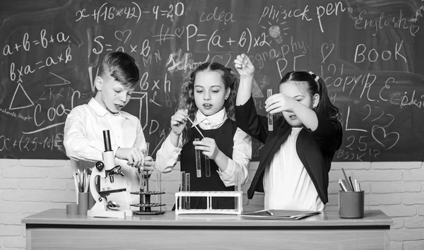 Boy and girls enjoy chemical experiment. Organic chemistry is study of compounds containing carbon. Basic chemical reactions. Fascinating chemistry. Group school pupils study chemistry in school