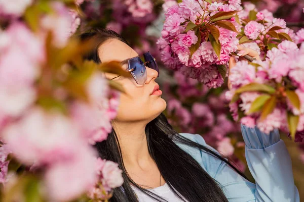 Aksesuar dükkanı. Bahar çiçeğinin açtığı süslü güneş gözlüklü kadın. Kiraz çiçekli kız. Bahar moda koleksiyonu. Sakura ağacı çiçek açıyor. Sakura ona yakışıyor. Muhteşem çiçek ve dişi güzellik — Stok fotoğraf