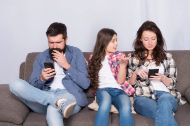 Çocuğu görmezden gelmeyi bırak. İnternete takıldım. Görmezden gelinen çocuk. İnternetteki akıllı telefonlarda sörf yapan ebeveynler. Baba ve anne, kızının ihtiyaçlarını görmezden geliyorlar. Kötü alışkanlıklar. Ebeveynlik başarısızlığı. Görmezden gelinen bebek. Gücenmiş duygular