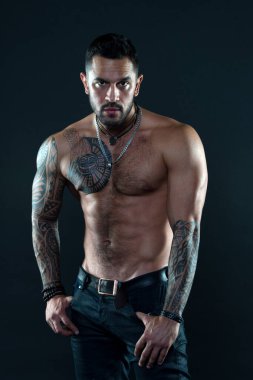 Baştan çıkarıcı bir bakış. Dövmeli sakallı bir adam. Maço seksi çıplak gövde. Cildinde dövme resmi olan uygun bir model. Sakallı ve saçlı sporcu ya da sporcu. Spor ve spor. Erkeklik. Kas gövdesi