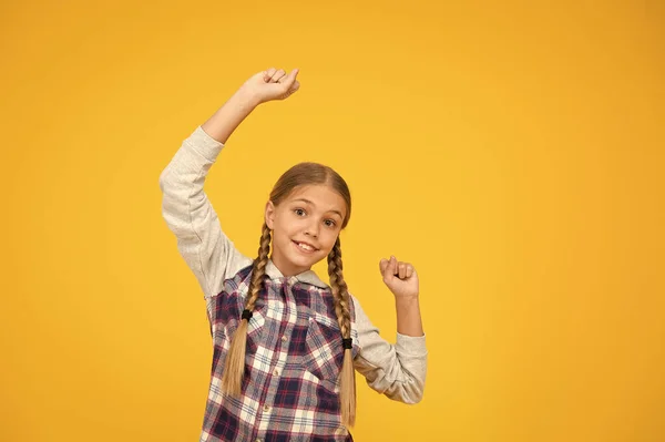 Divirtiéndose. Linda chica trenzada. Cabello largo de niño. Camisa a cuadros de niña pequeña. Feliz día internacional de los niños. Niña de fondo amarillo. Concepto de buen humor. Vibraciones positivas. Emociones sinceras — Foto de Stock