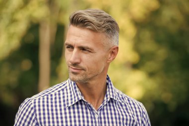 Yakışıklı ve kendinden emin. Yazın açık havada yakışıklı bir adam. Yakışıklı yüzlü olgun bir insan. Moda ve tarz. Yaşlı erkekler için tımar ve tarz. Yakışıklı ve bakımlı.