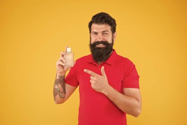 Losyon spreyi. Parfüm ürünleri konsepti. Sakallı, yakışıklı adam şişe parfümü kullanıyor. Parfüm sürmüş. Misk kokulu madde, genelde temel notalarda kullanılır. Parfümü duruma göre seç