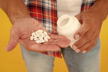 Sadece bir hap yardımcı olabilir. Erkek sağlığı için gıda katkı maddeleri. Biyolojik vitamin kompleksi. Hastalık tedavisi. Erkek uyuşturucu kavanozu. Adam vitamin hapı kutusunu tutuyor. Tıp konsepti. anabolik ve steroidler