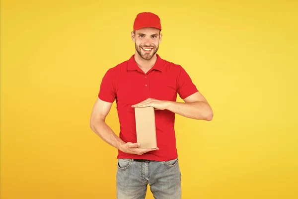 Afgeleverd op uw bestemming. Dienstverlening. Loopbaan als verkoper. Koerier en bezorging. Postbode bezorger. Man rode pet gele achtergrond. Aankoop afleveren. Sneller dan je je kunt voorstellen — Stockfoto