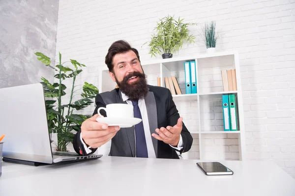 Neem wat en geniet ervan. Happy boss serveert hot cup aan het bureau. Werkgever geniet van koffie in kantoor. Goeiemorgen. Ontbijt thee. Drink en geniet ervan. Eet smakelijk. — Stockfoto