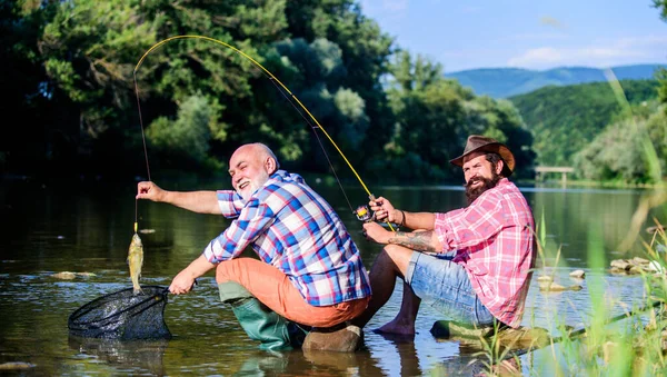 Père retraité et fils barbu mature. pêche au gros gibier. relaxer sur la nature. voler poisson passe-temps des hommes. pêche à la retraite. heureux pêcheurs amitié. Deux amis pêchant ensemble. Bonne journée pour la pêche — Photo