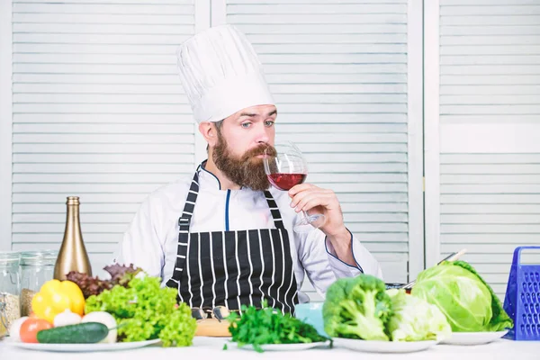 Matcha vin och mat som en expert. Man bär hatt och förkläde njuta av smakdryck. Mäster kock hålla glas vin. Tillsätt lite alkohol. Vilket vin serverar till middag. Vindegustation. Koncept för haute cuisine — Stockfoto