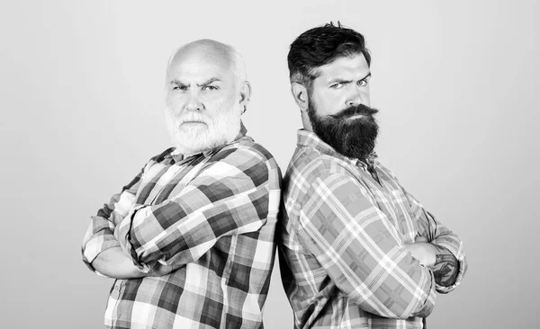 Bearded friends. Hairdresser salon. Barbershop concept. Men bearded hipster stand back to back. Family team. Brutal guys with long beard. Barber well groomed handsome bearded man. Father and son