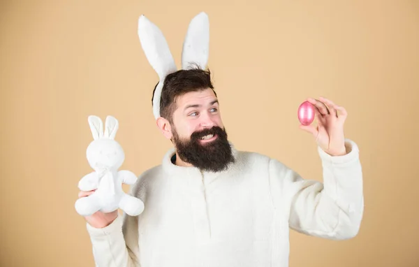 Vreemd concept. Vier Pasen. Man met baard hipster raar konijn met lange witte oren beige achtergrond. Paashaas. Man in konijnenpak. Grappige konijnenman zachte oren. Paasactiviteitenconcept — Stockfoto