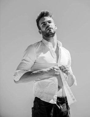 Çekici bir adamın gömleğini çıkarması. Cazibesine güveniyor. Sakallı adam iş stili. Yakışıklı bir manken. Seksi maço adam. Açık havada sıcak bir gün. Sıcaklık mevsimi. Resmi moda. Resmi biçim