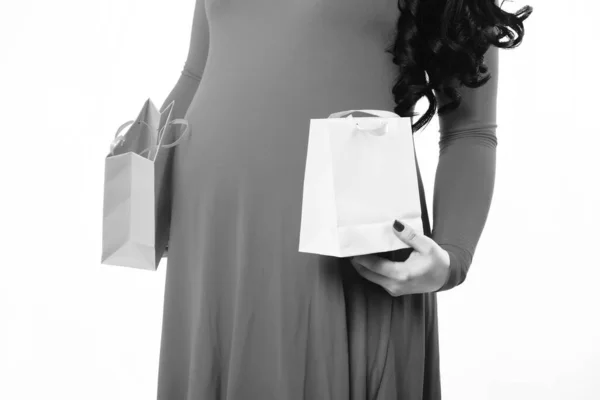Женские руки беременной женщины с пакетом или сумками — стоковое фото