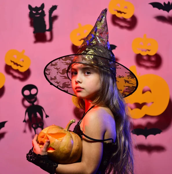 Een kleine heks met een zwarte hoed. Meisje met rustig gezicht — Stockfoto
