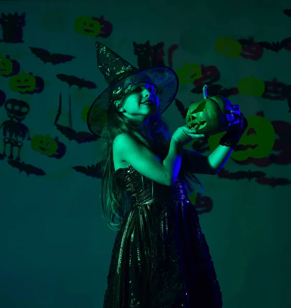 A kis boszorkány fekete kalapot visel. Kísérteties boszorkány jelmezes kölyök. — Stock Fotó