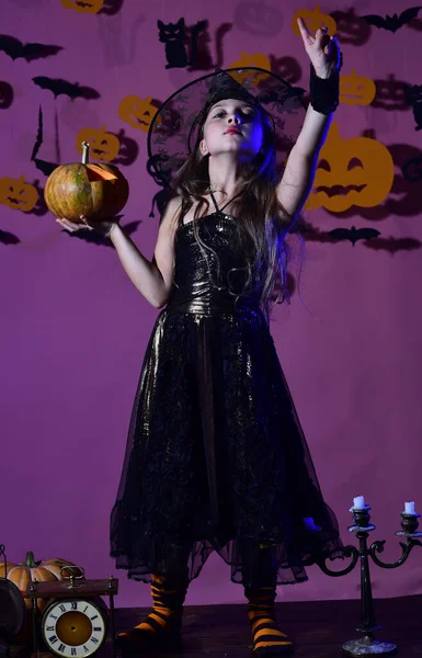 Een kleine heks met een zwarte hoed. Kind in griezelige heksen kostuum — Stockfoto