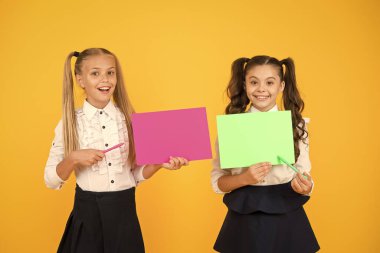 Öğrenmen gereken önemli bir ders. Sevimli küçük çocuklar sarı arka plan üzerinde kalem ve kağıt ile ders okuyor. Küçük kızların yazılı dersi var. Derste heyecan verici fikirleri kullanarak, kopyalama alanı