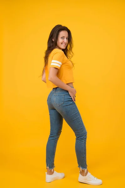 Calça jeans Skinny combina com ela. A auto-confiança é a melhor roupa. Menina sexy fundo amarelo. Rapariga sexy. Menina sensual em estilo casual. Menina bonita com cabelo comprido. Moda e estilo. Beleza e maquiagem — Fotografia de Stock