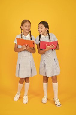 Okul kütüphanesi. Okullar için eğitim kitapları. Kitap okuyorum. Evde eğitim konsepti. Okuryazarlık kulübü. Sarı arka plan üzerine kitaplar tutan sevimli çocuklar. Ansiklopedi veya çocuk kitapları ile küçük kızlar