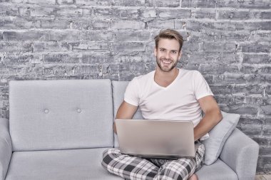 Evden bağımsız olarak çalışıyor. Karantinadayken uzak mesafe işi. Yakışıklı adam dizüstü bilgisayarla iletişim kuruyor. Uyumadan önce defter kullan. Erkek blogcu internet teknolojisi kullanıyor. Bilgisayarda ağ oluşturma