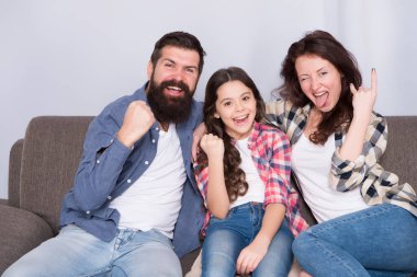 Sonunda hafta sonu. Küçük kız ailesiyle rahatlıyor. Evde kal. Aile kanepeye oturur. Mutlu baba, anne ve kız. Karantina ve tecrit kavramı. Gülümseyen aile. Birliktelik bizim gücümüz.