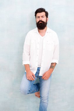 Yaz modası. Sakallı manken kıyafeti. Moda modeli. Sakallı, olgun, yakışıklı hippi beyaz gömlek giyiyor. Yaz koleksiyonu. Erkek giyim konsepti. Moda kıyafetleri. Çekici adam duvar arkaplanı