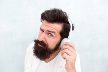 Enstrümantal müzik. Sakallı adam kulaklıkları. Her notanın tadını çıkar. Aktif Ses İptal Teknolojisi. Hippi müzik kulaklığı dinler. Modern kablosuz kulaklık. Elektronik dans müziği parçaları