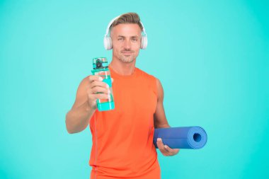 Sağlık önceliklidir. Sağlıklı bir adam yoga eğitimi için su tutar. Spor salonu koçu mavi arka plan. Su ve hidrasyon. Sağlık sigortası. Su seviyesi ve sağlık düzeyi artıyor. Sadece sağlık alışkanlığı.