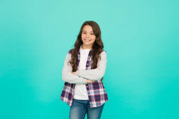Ambitious and beautiful. schoolgirl has long curly hair. child in trendy casual jacket. kid spring and autumn fashion. little beauty. express positive emotions. happy small girl turquoise background — Stock Photo, Image
