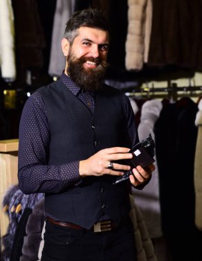 Gülümseyen adam cüzdanı dükkanda tutuyor..